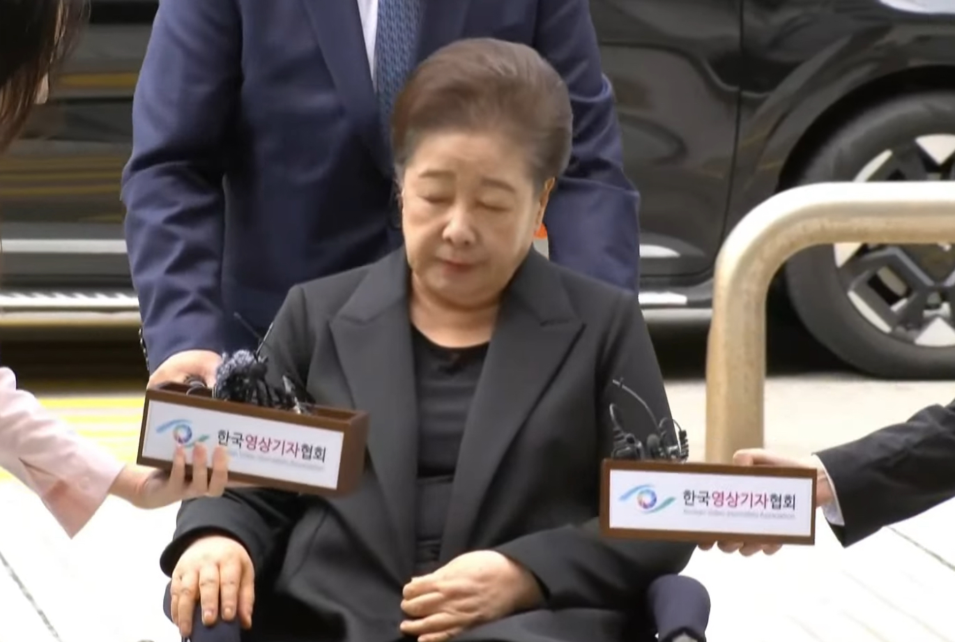 Mother Han arriving at the pre-arrest hearing on a wheelchair. Screenshot.