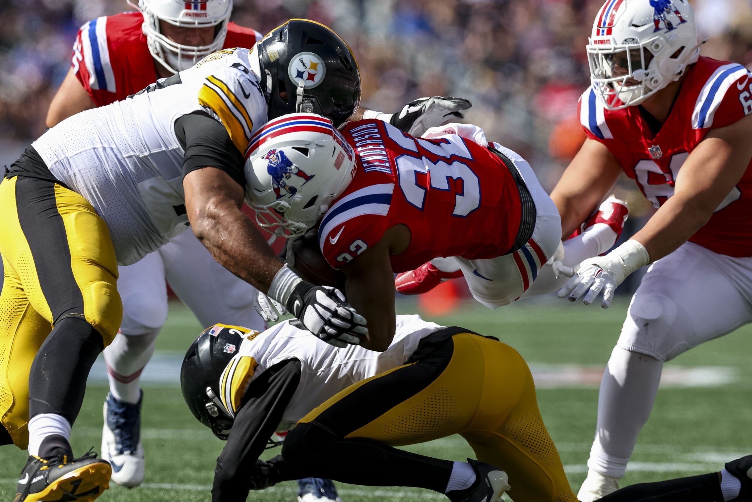 Sep 21, 2025; Foxborough, Massachusetts, USA; New England Patriots running back Treveyon Henderson (32) is tackled by Pittsburgh Steelers defensive tackle Cameron Heyward (97) during the second quarter at Gillette Stadium. Mandatory Credit: Paul Rutherford-Imagn Images